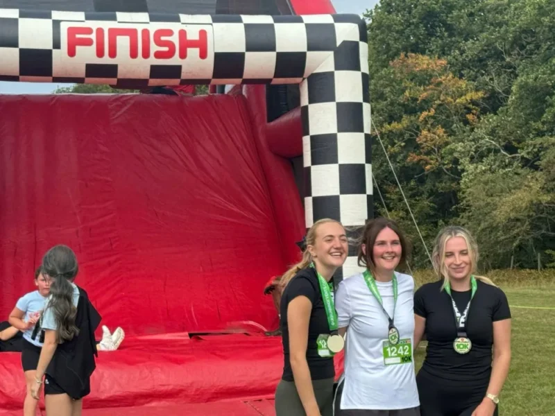 Runners celebrating next to an inflatable obstacle course.