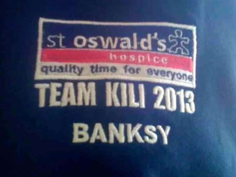 A jumper with lettering that reads 'Team Kili 2013 Banksy'.