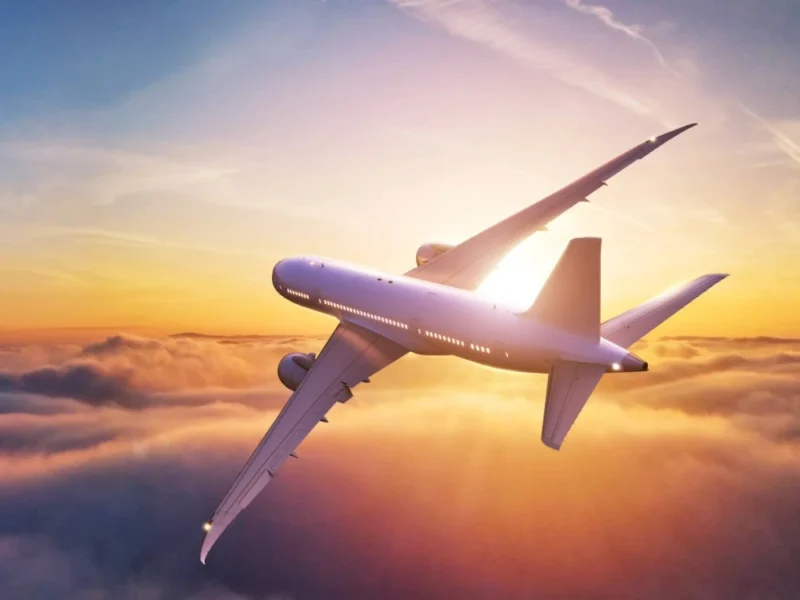 A plane flies off into the sunset.