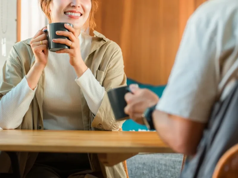 Two people drinking coffee and chatting.
