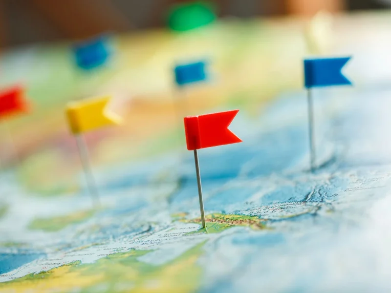 A series of colourful flags pinned to a map of the world.